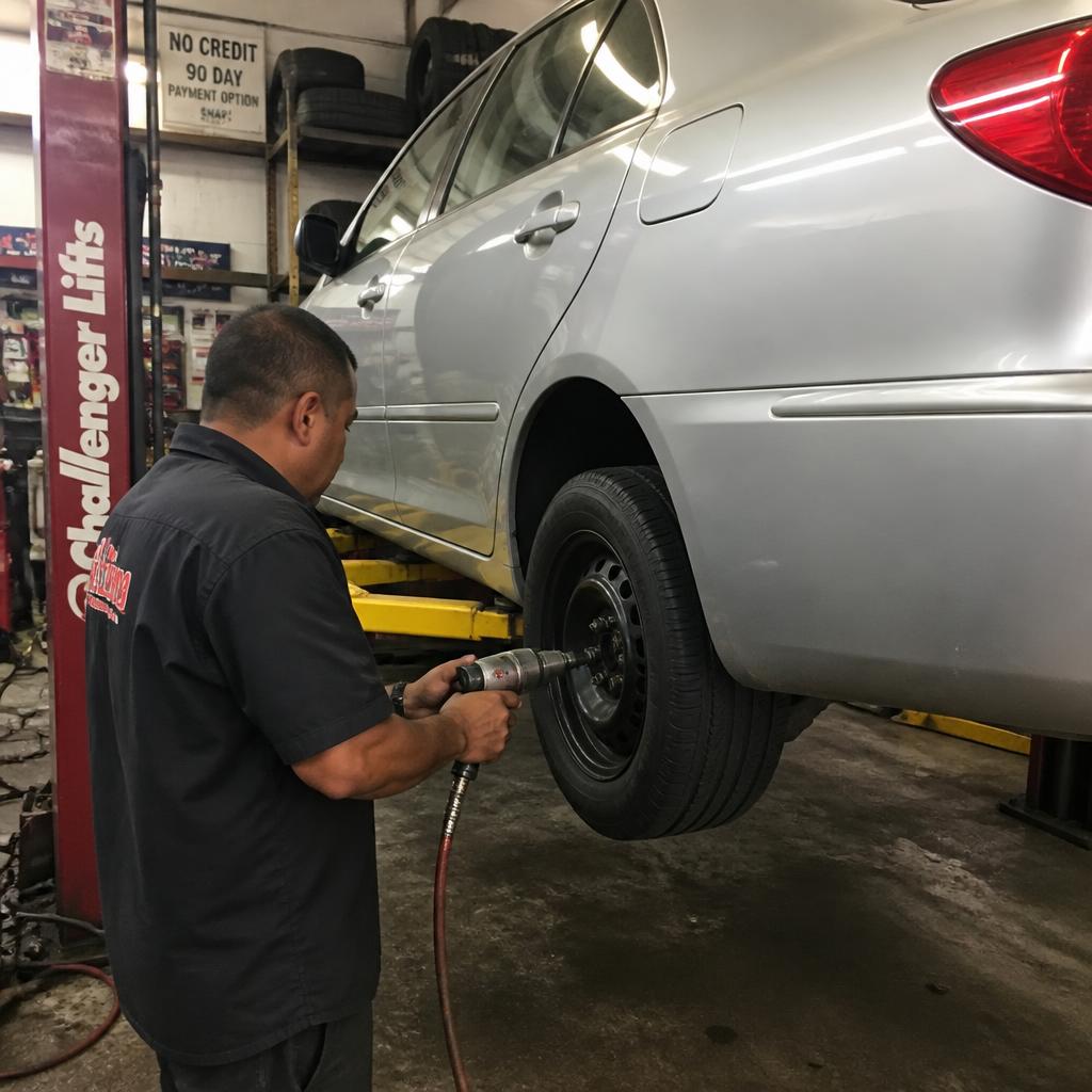 FG Auto technician working on a vehicle with an impact wrench